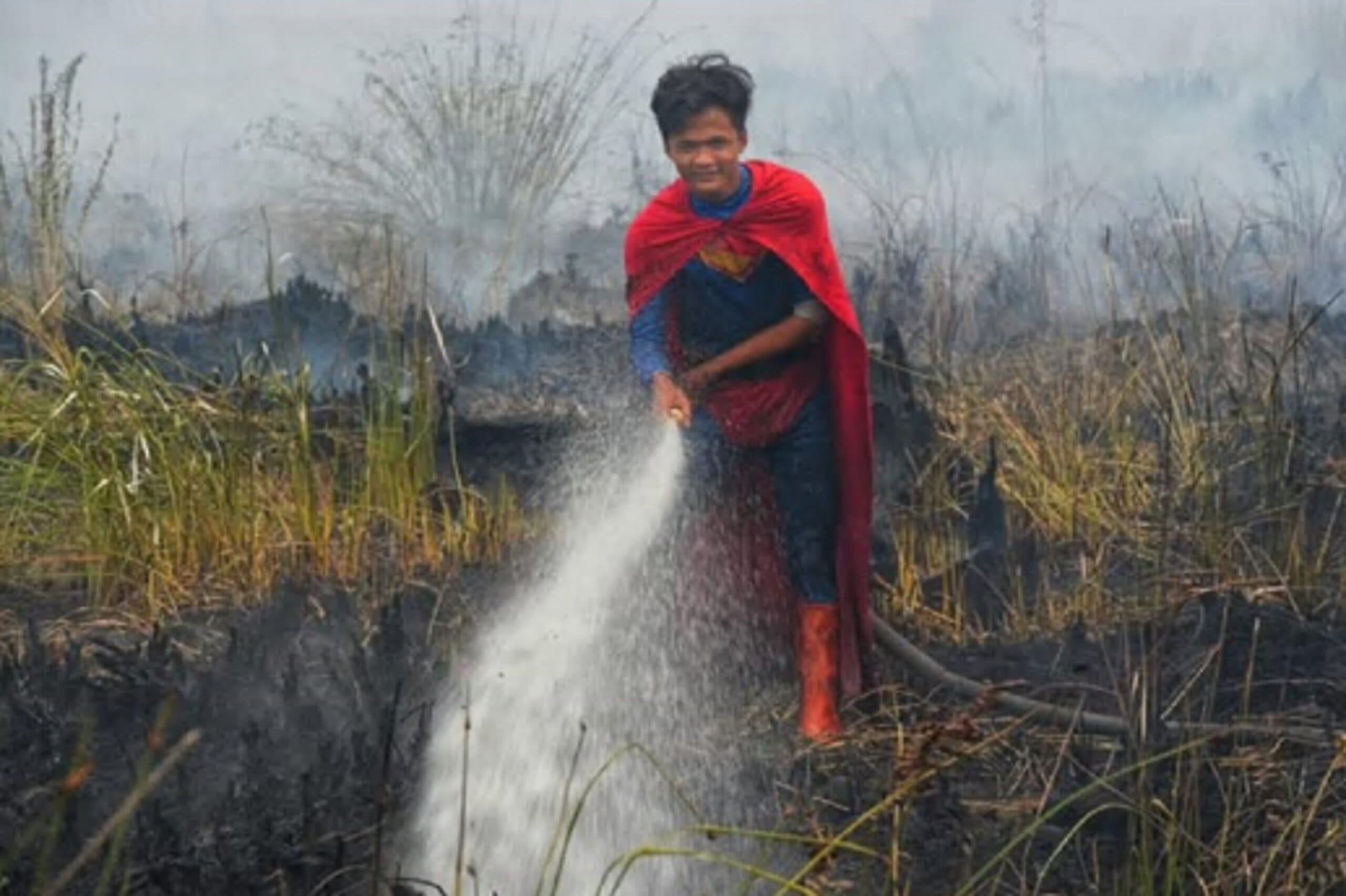 Vestito da Superman spegne incendi, il 17enne indonesiano star del web: Il governo lo nomina "eroe"